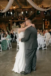 Kelsey and Andrew dance together inside the barn at Whispering Pines Venue