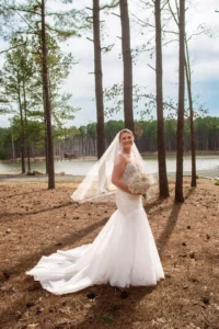 Bride Madison glows in her white gown, standing amidst the towering pines