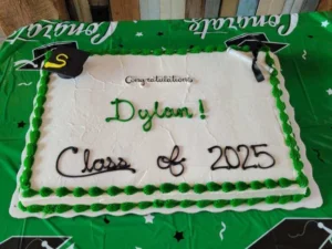 A white cake with green frosting borders.