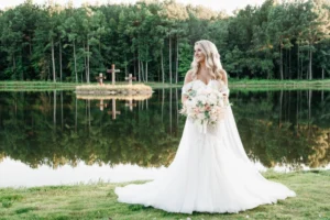 Callie Reaves glowing in her bridal portrait at Whispering Pines Venue, surrounded by lush pine trees and soft natural light.
