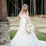 Close-up of Callie Reaves’ bridal portrait at Whispering Pines Venue, highlighting her elegant gown and serene expression amidst the venue’s greenery.