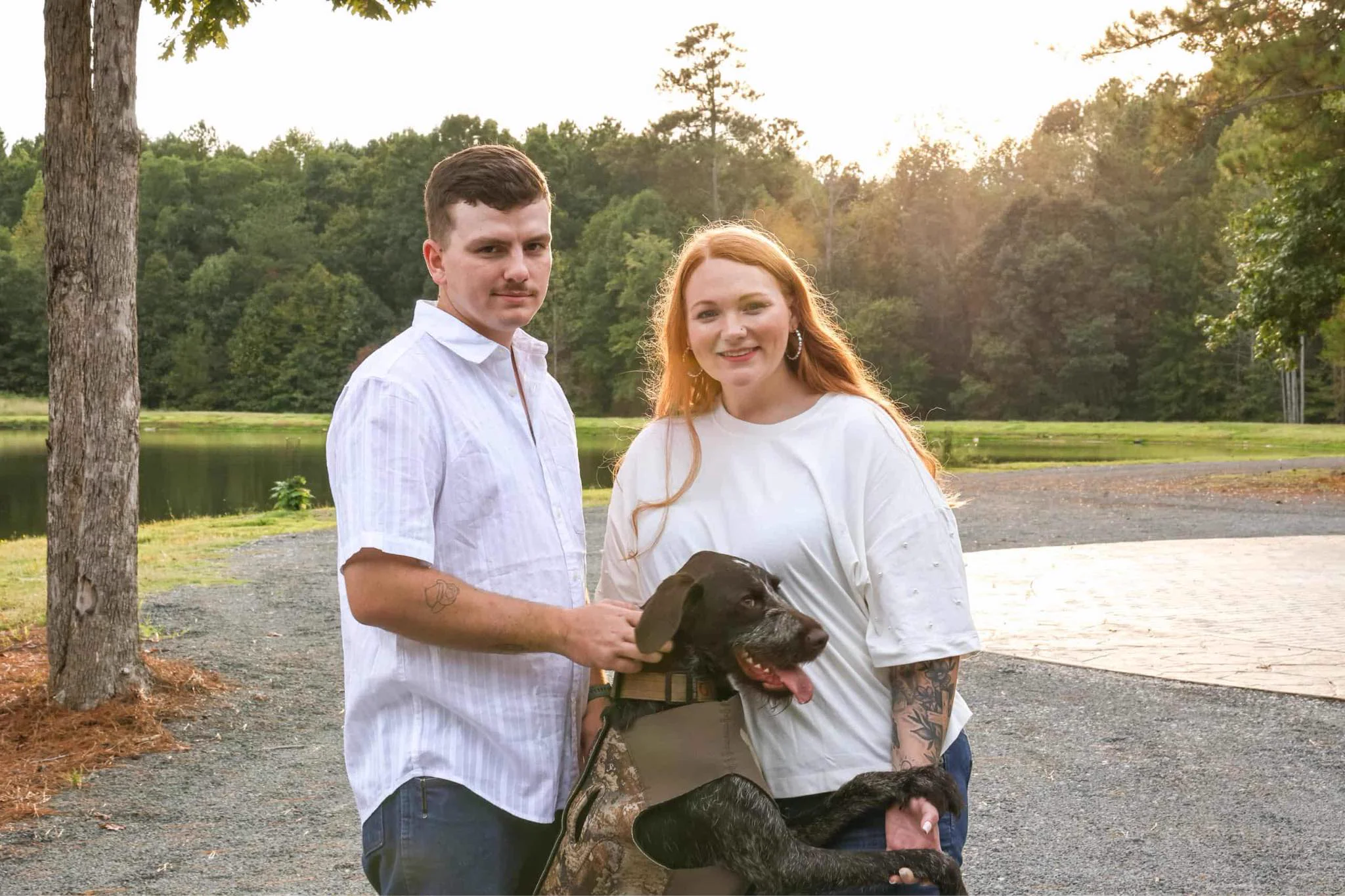 Ryan and Jordan posing romantically by the peaceful pond at Whispering Pines Venue, framed by golden light and open fields in the serene Vance County countryside