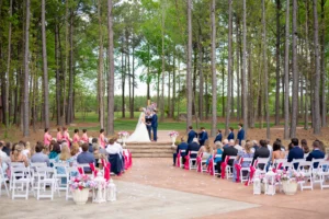 Wedding ceremony at Whispering Pines Venue with guests seated and watching the bride and groom exchange vows.