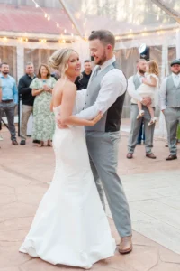 Bride and groom sharing their first dance inside Whispering Pines Venue during their spring wedding reception.